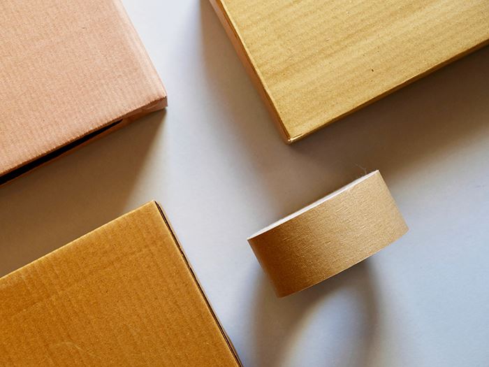 Verpackungsmaterialien, wie Kleberollen und Pakete.
